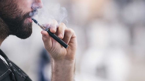 Male head in profile with steaming e-cigarette