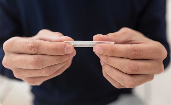 Hände, die eine Zigarette drehen.