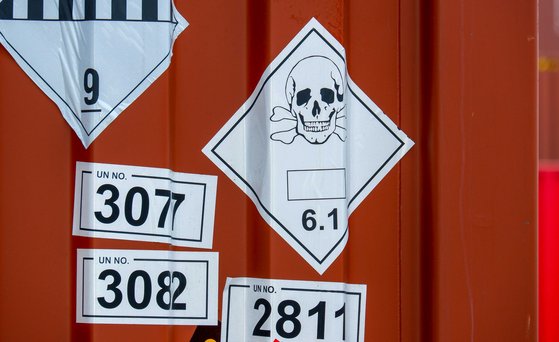 Transport_gefährlicher_Güter Nahaufnahme von Container-Wand mit verschiedenen Symbolen.