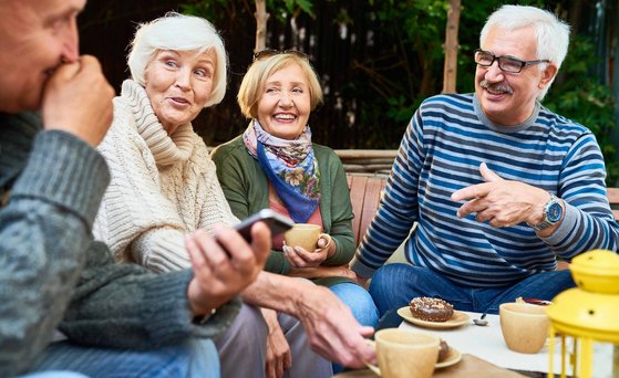 Elderly people sitting in a group laughing